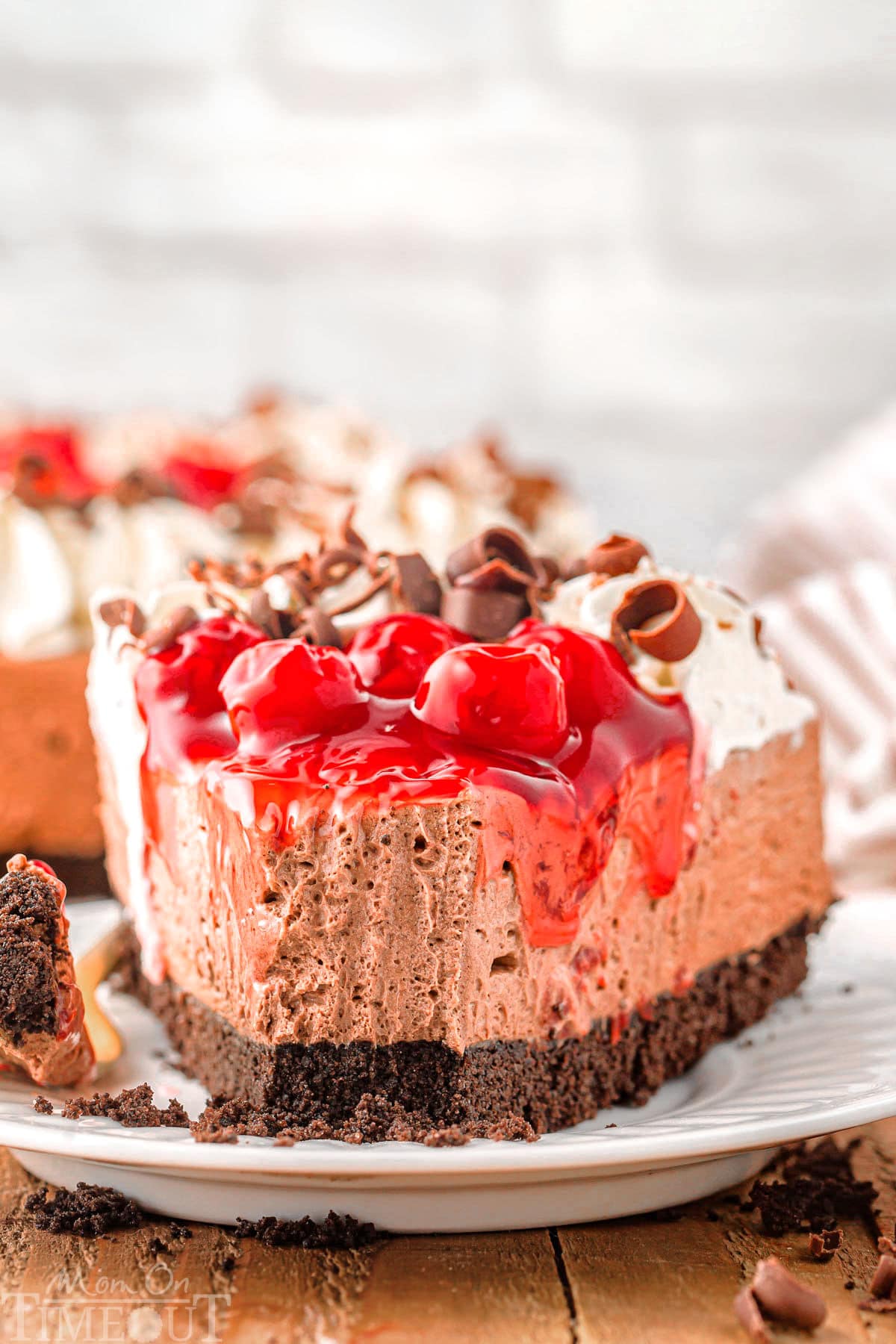 Piece of no bake black forest cheesecake recipe on plate with bite taken.