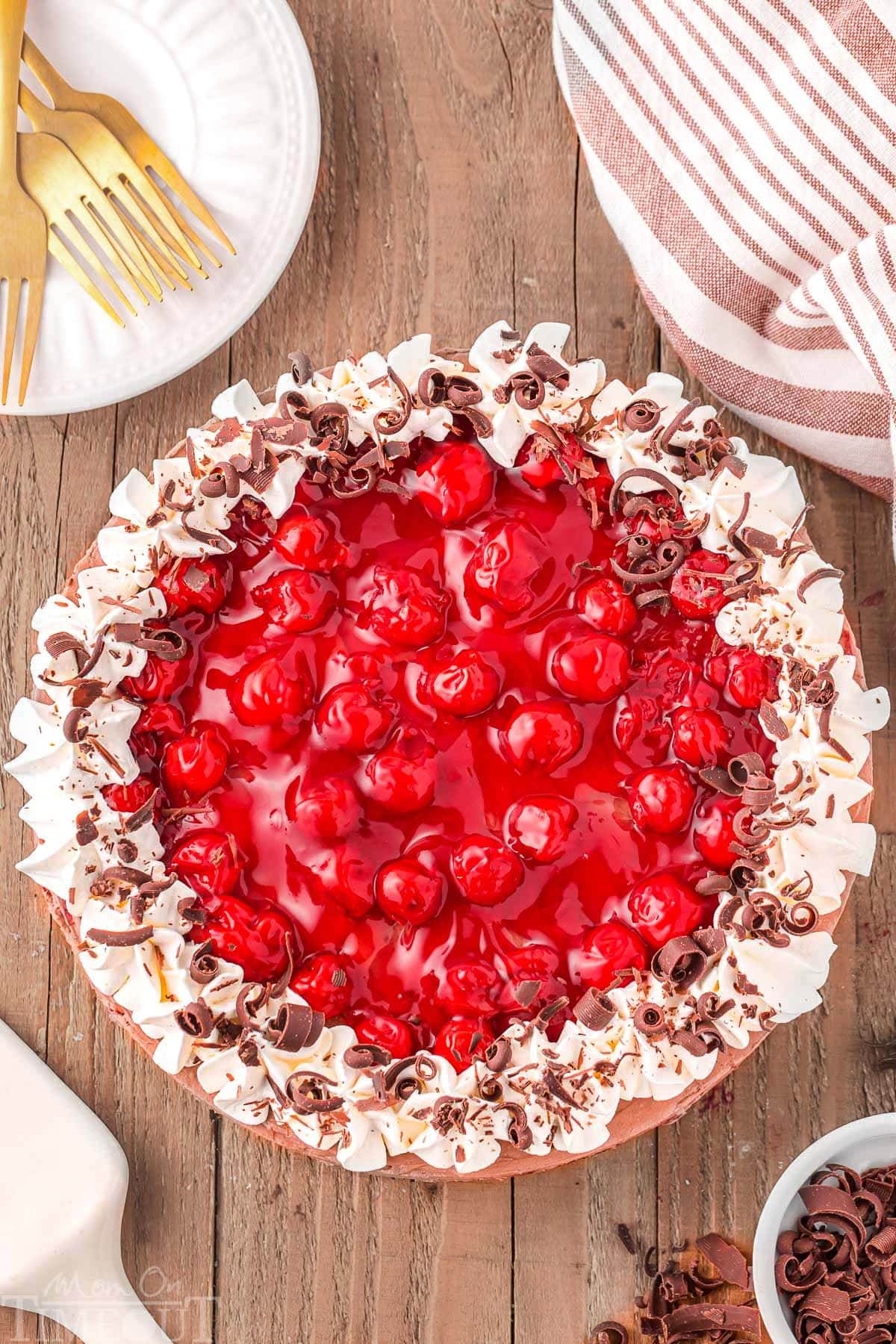 Top down view of whole no bake black forest cheesecake sitting on wood board.